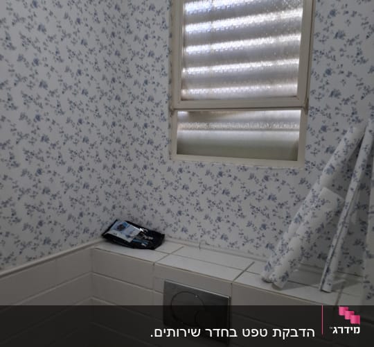 קיר עם טפט פרחוני כחול ולבן בחדר אמבטיה